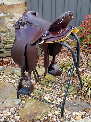 Black endurance saddle with leather covered stirrups and edge tooling